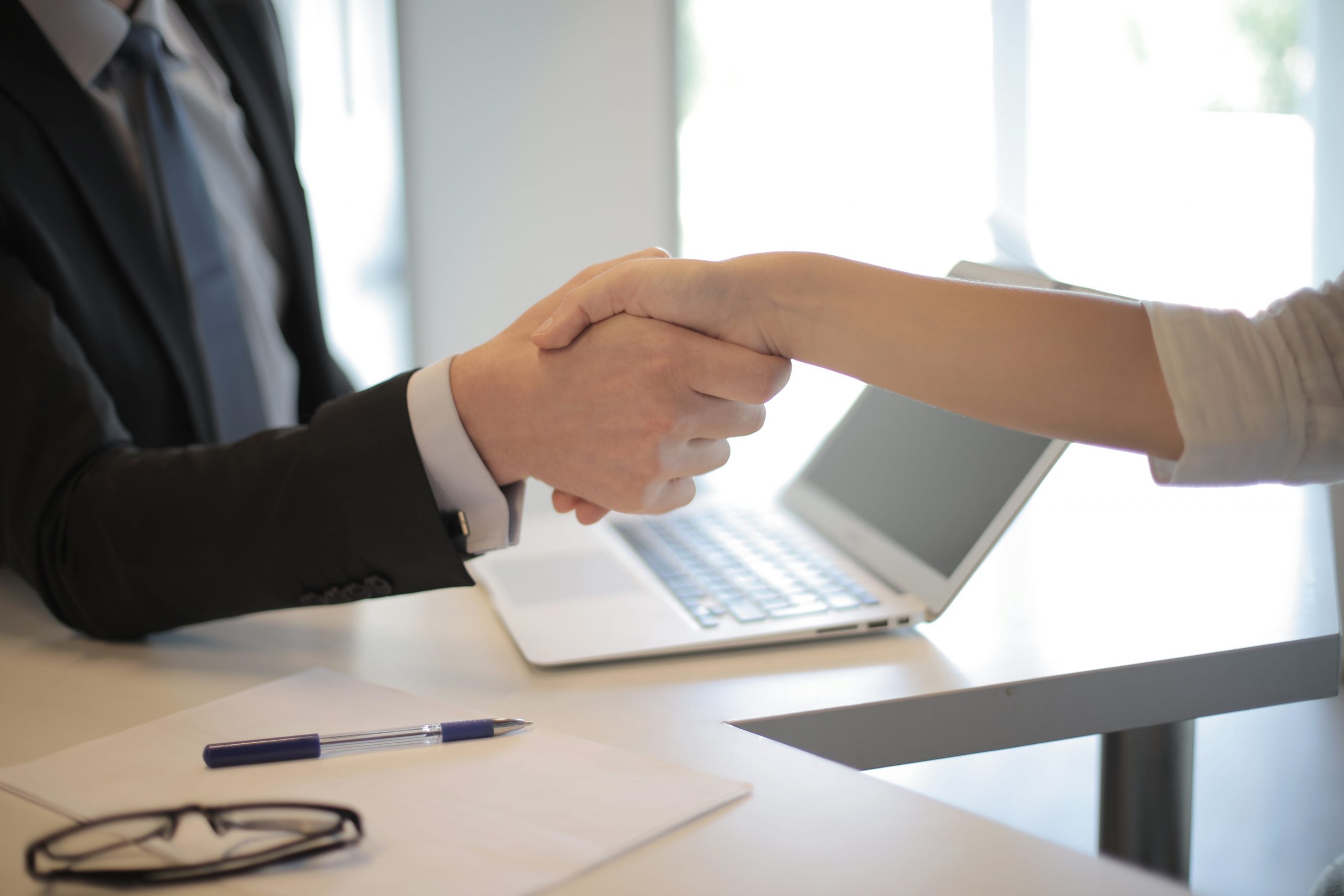 two people shaking hands over business deal